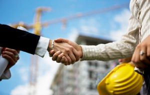 Two people handshakign outdoors in construction zone