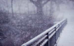 Bridge covered with snow falling