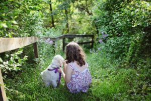 child with dog in grass